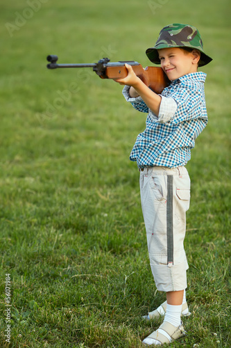 little boy with airgun outdoors