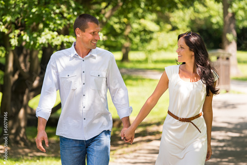 Couple walking and laughing in a park © CandyBox Images