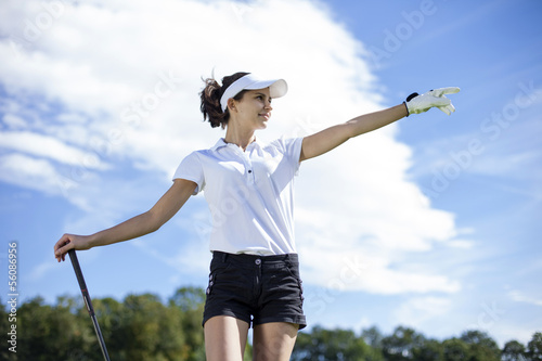 Pretty girl playing golf on grass