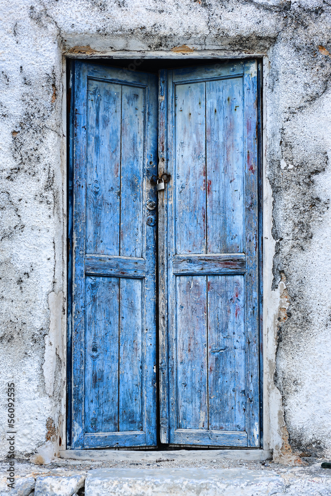 Old weathered blue door in Perissa