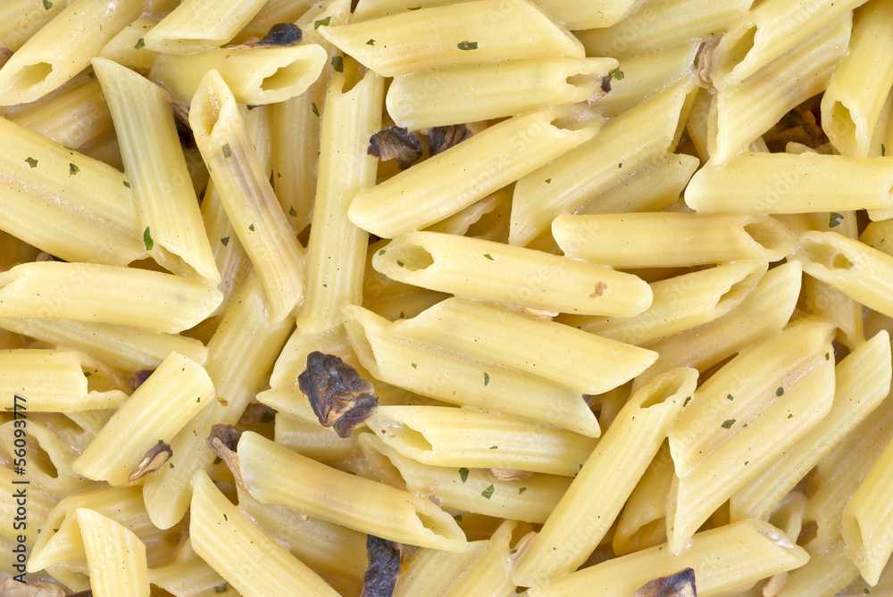 A very close view of cooked penne with mushrooms A very close view of cooked penne with mushrooms