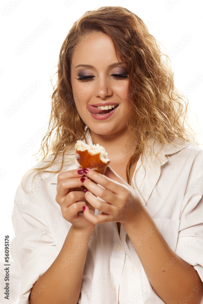 girl in white shirt licks her lips while looking at her donut girl in white shirt licks her lips while looking at her donut