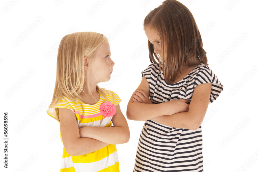 Two sisters with arms folded angry looking at each other