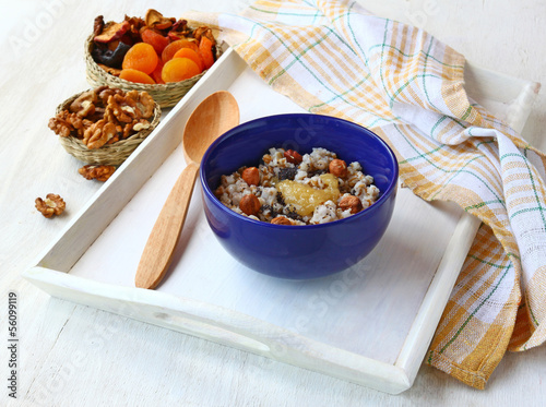 A bowl of wheat cereal with nuts, honey, raisins and poppy seeds photo