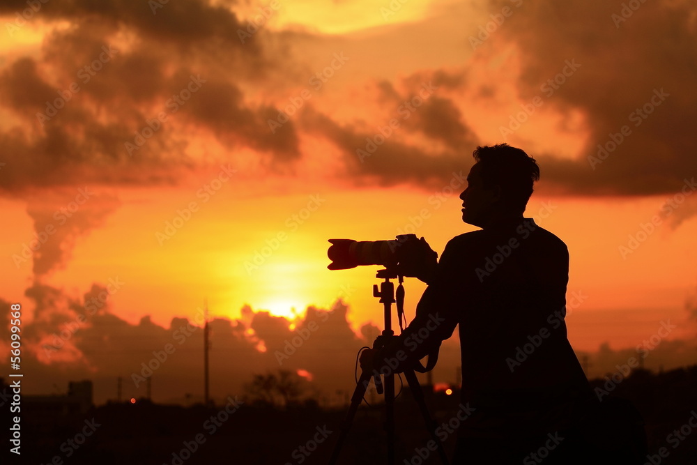Silhouette of young photographer at sunrise