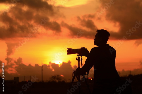 Silhouette of young photographer at sunrise