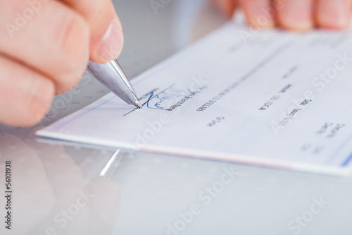Hand With Pen Over Checkbook