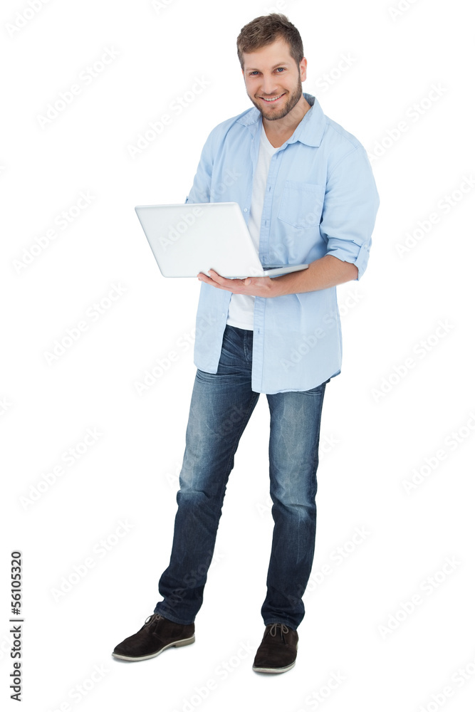 Smiling man using his laptop looking at camera Smiling man using his laptop looking at camera