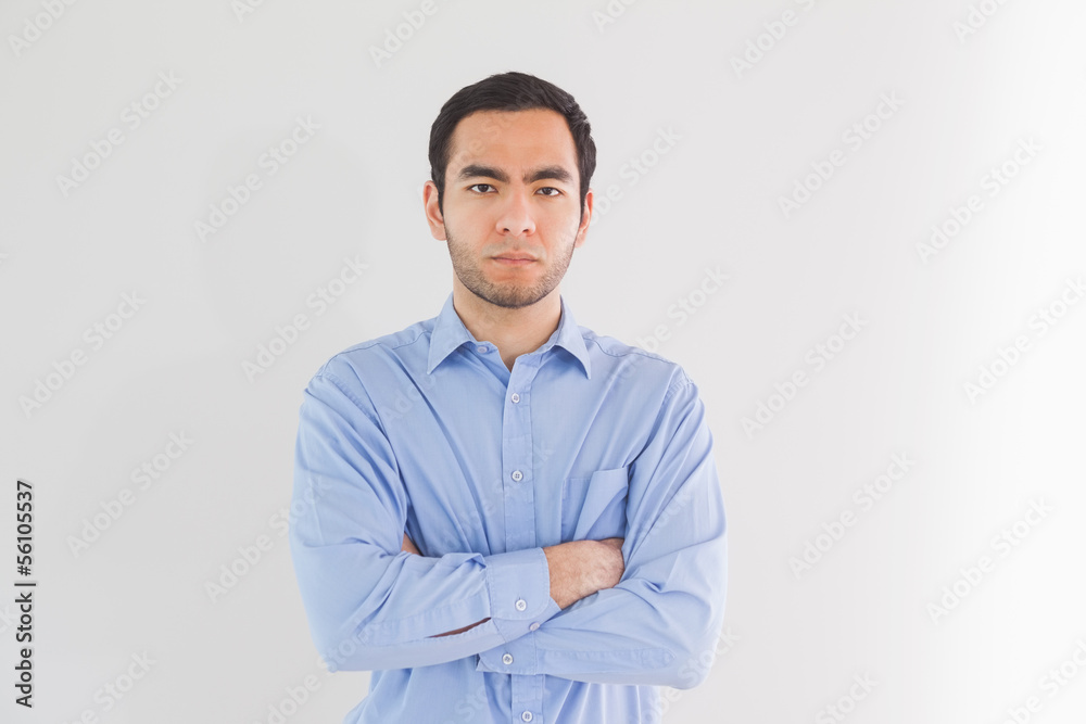 Serious man standing with arms crossed and looking at camera Serious man standing with arms crossed and looking at camera