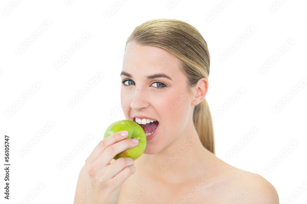 Smiling attractive blonde eating green apple Smiling attractive blonde eating green apple