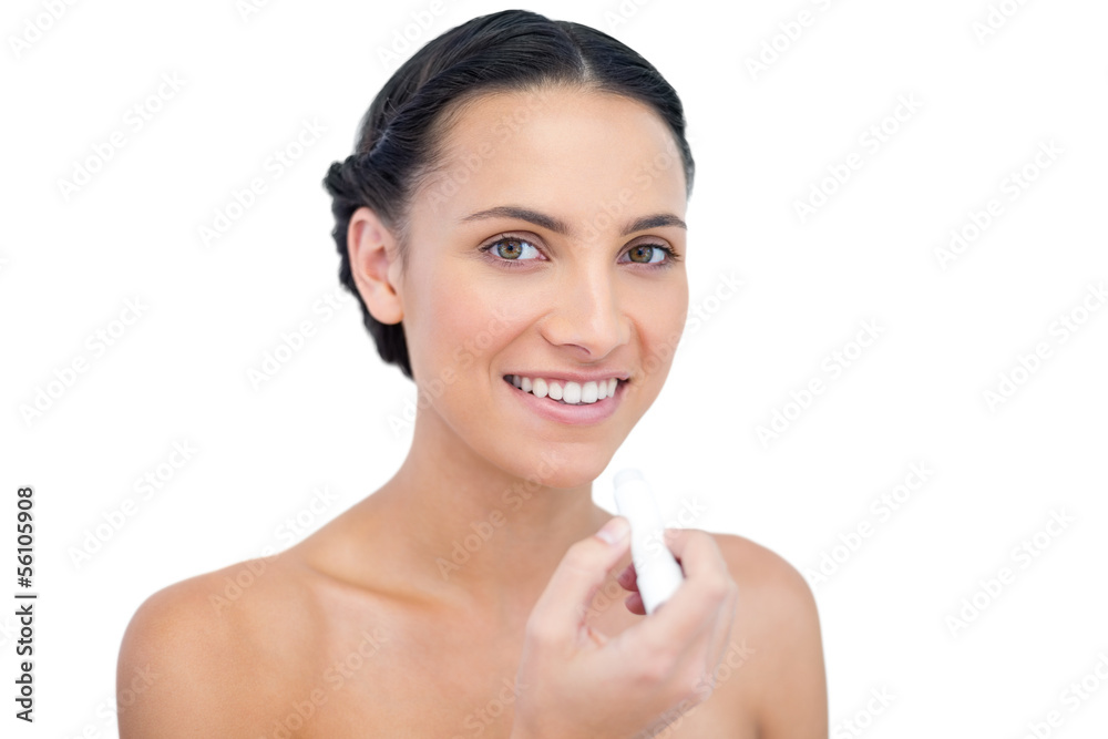 Smiling young natural model applying chap stick Smiling young natural model applying chap stick
