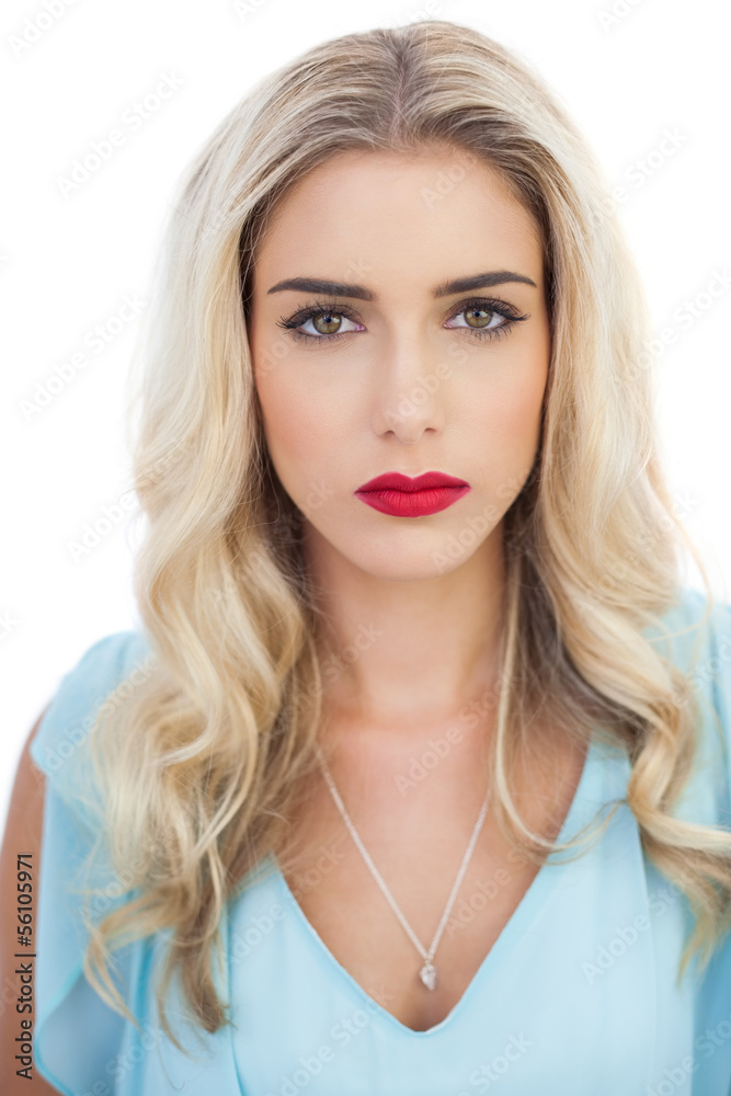 Portrait of a pensive blonde model in blue dress looking at came Portrait of a pensive blonde model in blue dress looking at came