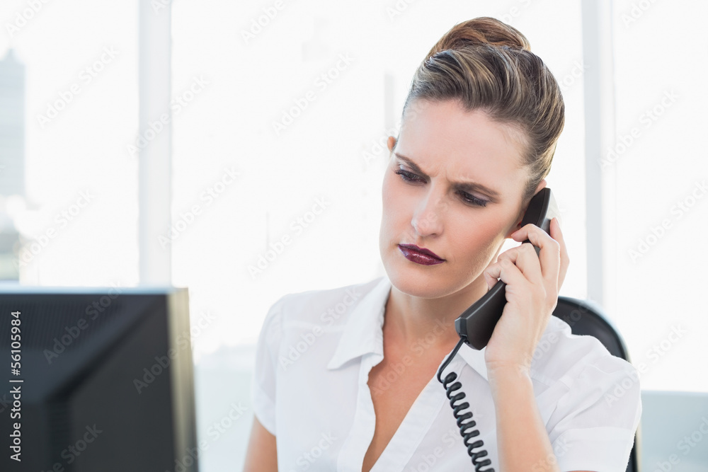 Unsmiling businesswoman talking on the phone Unsmiling businesswoman talking on the phone