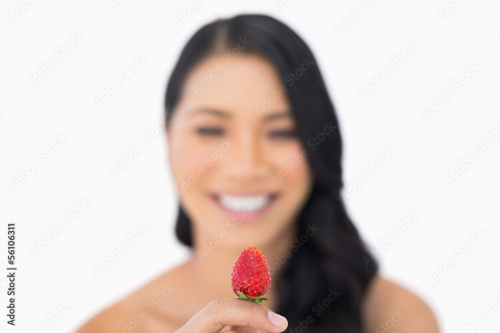 Attractive brown haired model holding strawberry Attractive brown haired model holding strawberry