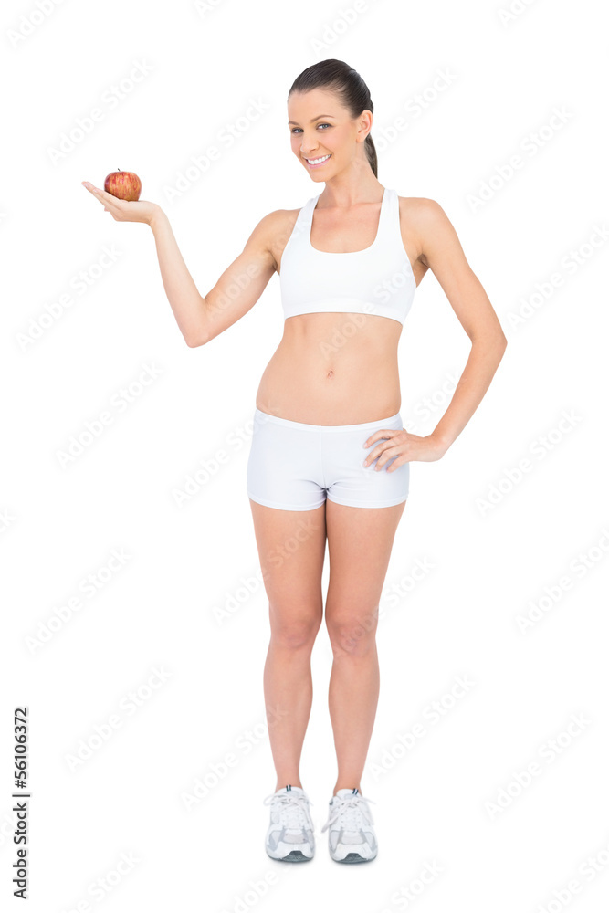 Smiling woman holding red apple looking at camera Smiling woman holding red apple looking at camera