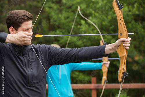 Handsome man practicing archery photo