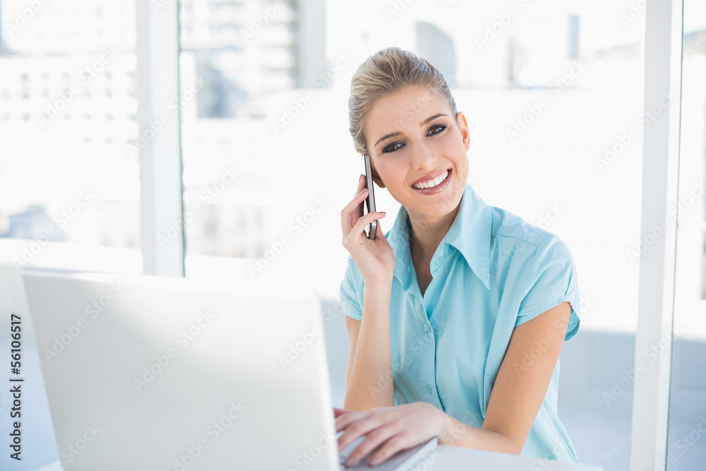 Happy smart businesswoman on the phone while using laptop Happy smart businesswoman on the phone while using laptop