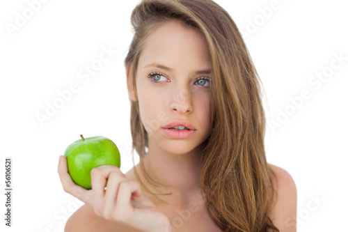 Wondering brunette model holding an apple