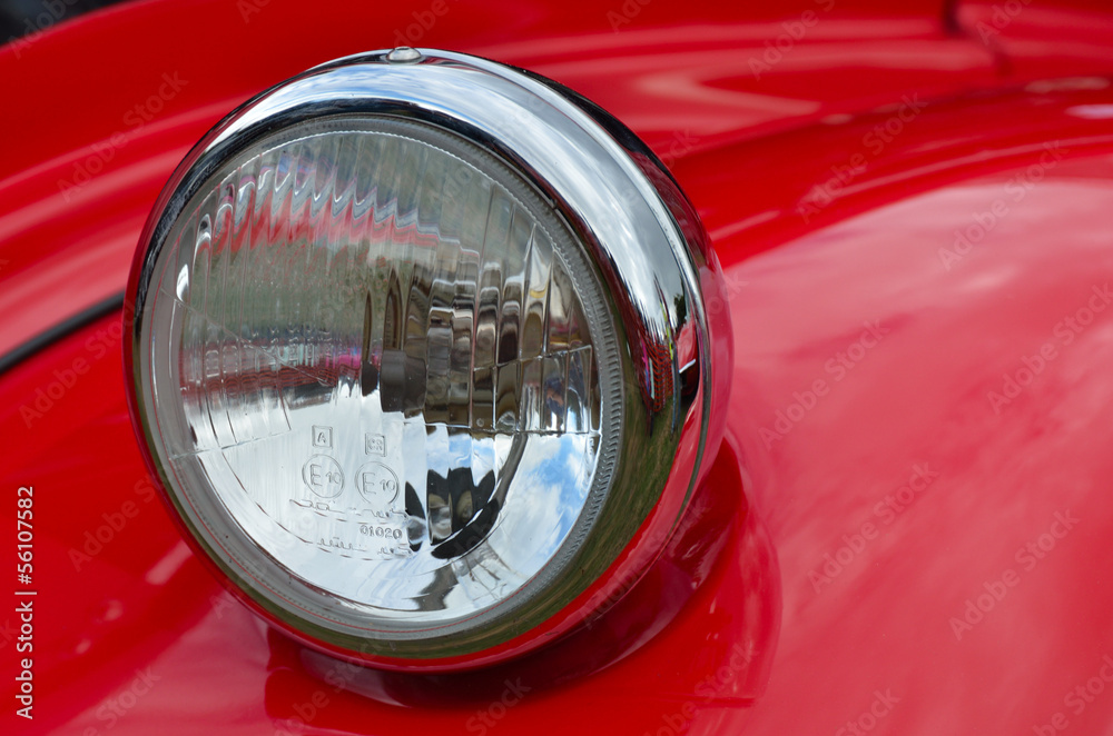 Detail of red headlamp on classic car