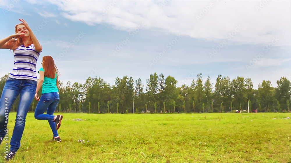 Teens running through the meadow, young people having fun Teens running through the meadow, young people having fun