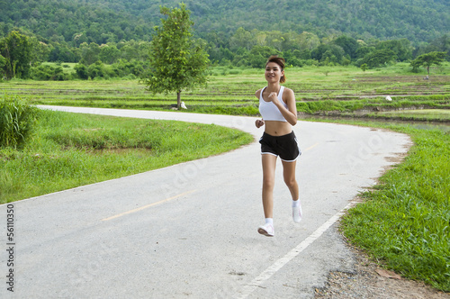 Beautiful Asian woman running on country road.
