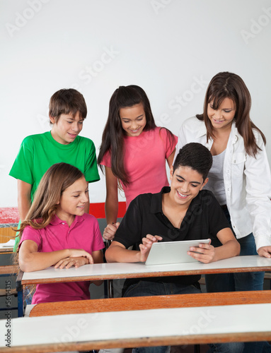 Teenage Friends Using Digital Tablet At Desk