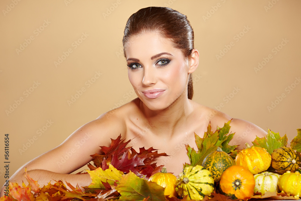 Fototapeta premium Woman with autumn pumpkin and leaves.