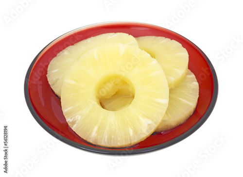 Serving of pineapple slices on a deep red dish