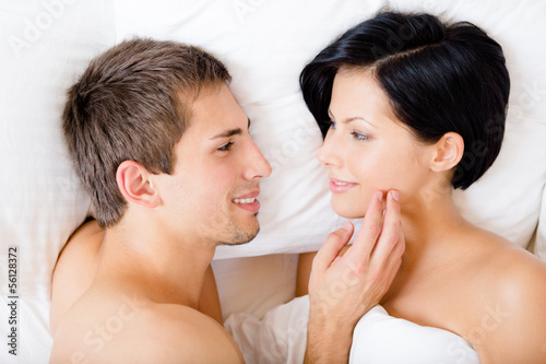 Close up of man stroking woman lying in bedroom