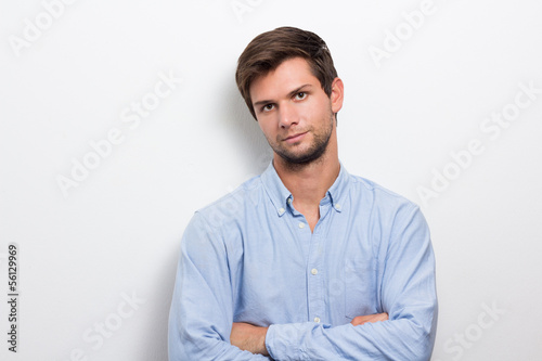 Young man with folded arms looking serious photo
