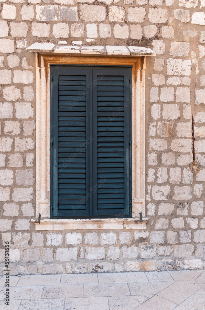 Framed ancient window with shutters