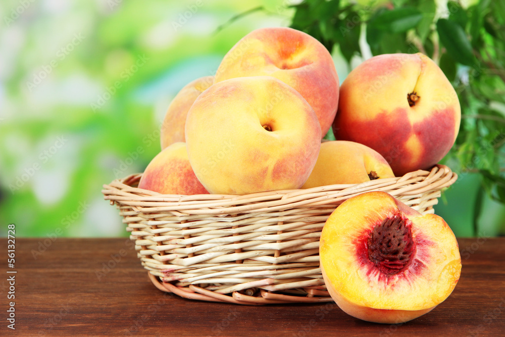 Ripe sweet peaches in wicker basket, on bright background Ripe sweet peaches in wicker basket, on bright background