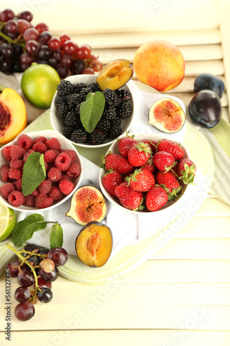 Assortment of juicy fruits and berries on wooden background