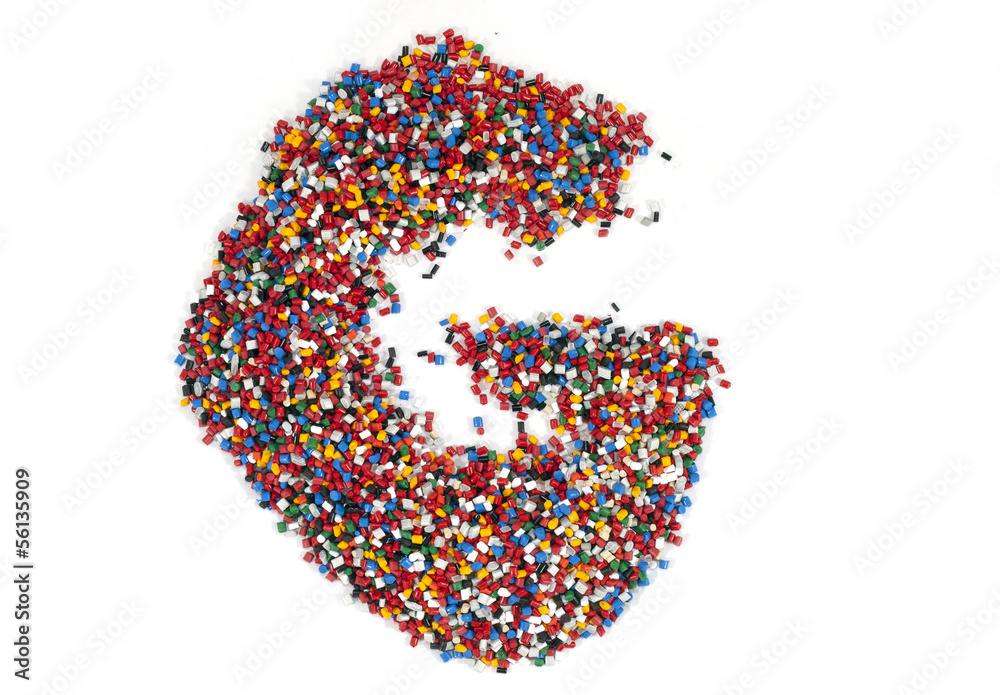 G shaped colorful plastic polymer granules on white background