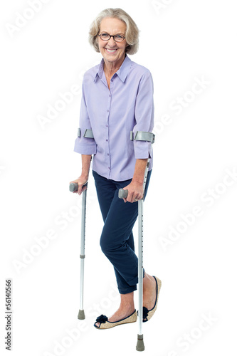 Carta da parati Bespectacled old woman walking with crutches