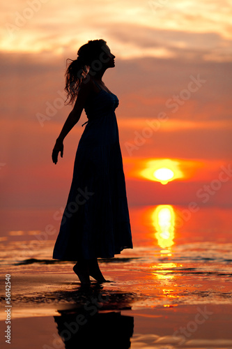 Happy Woman enjoying in Sea Sunset. Silhouetted against the suns © Miramiska