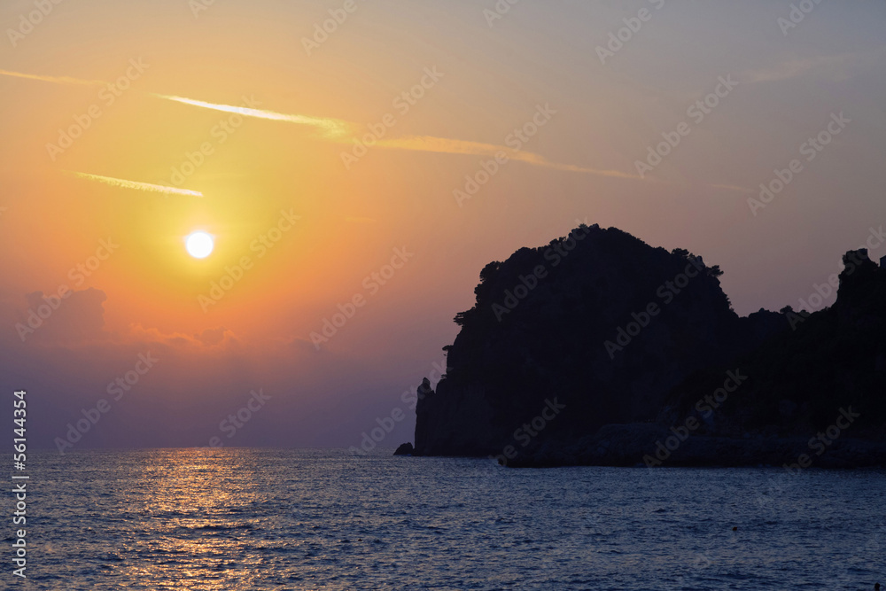 Sunset beach with big rock formation. Corfu. Greece. Ionian isla