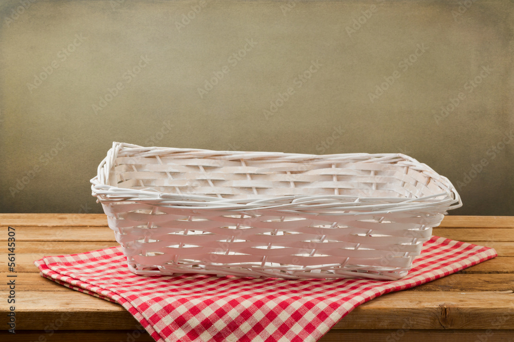 Empty white basket on checked red tablecloth