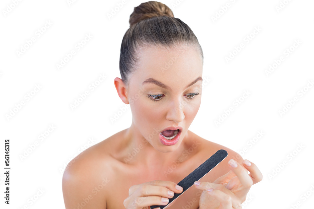 Obraz premium Pretty brunette using nail file