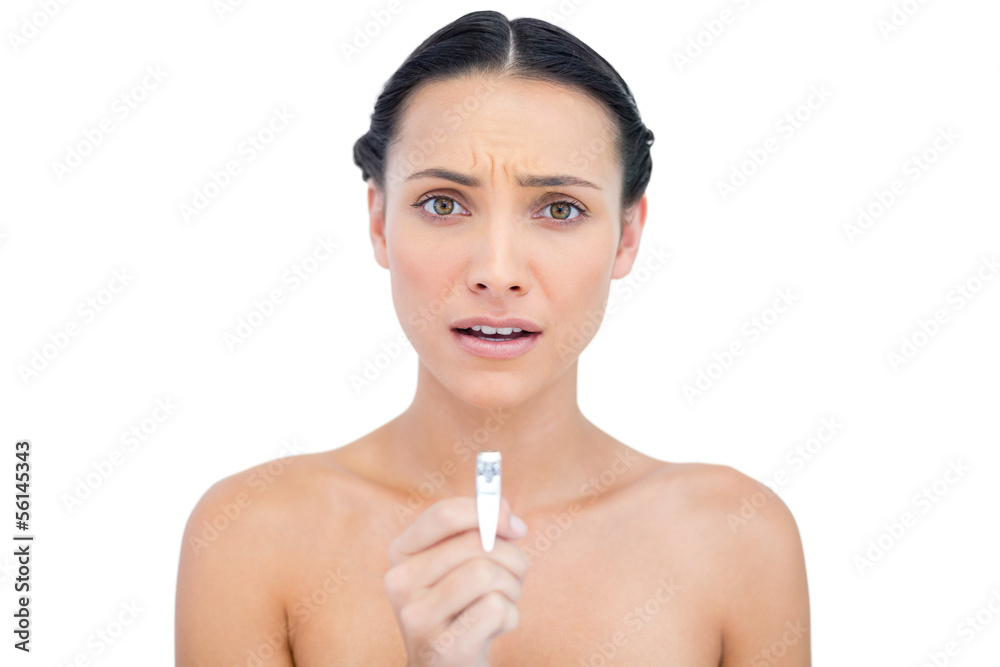 Anxious young brunette holding nail clippers Anxious young brunette holding nail clippers