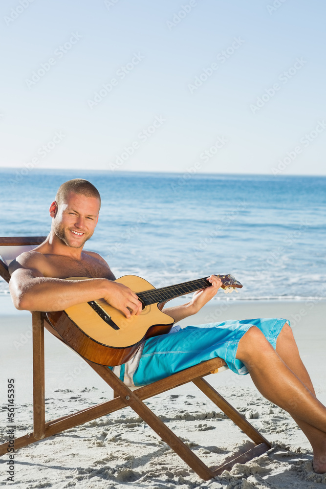 Cheerful handsome man strumming guitar