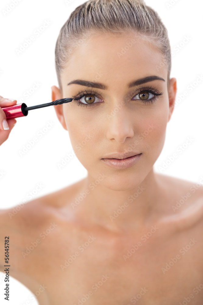 Concentrated woman applying mascara