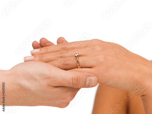 man puts wedding ring on woman hand