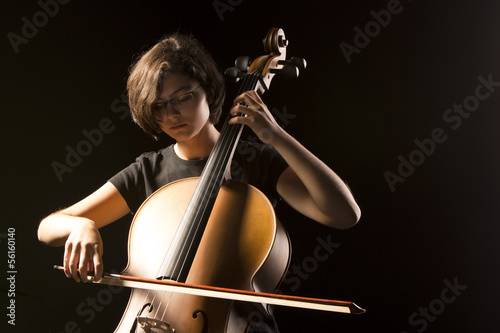 Young cellist isolated on black photo