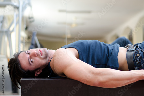 Handsome young man laying on his back, looking to a side