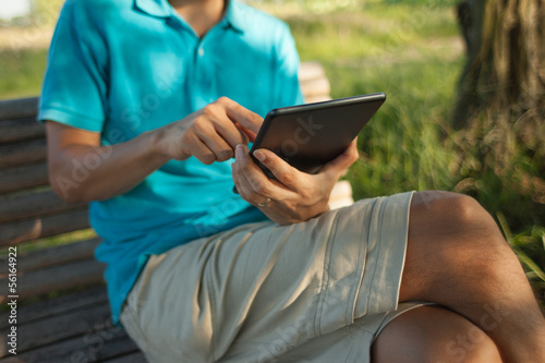 Man using a digital tablet outdoors