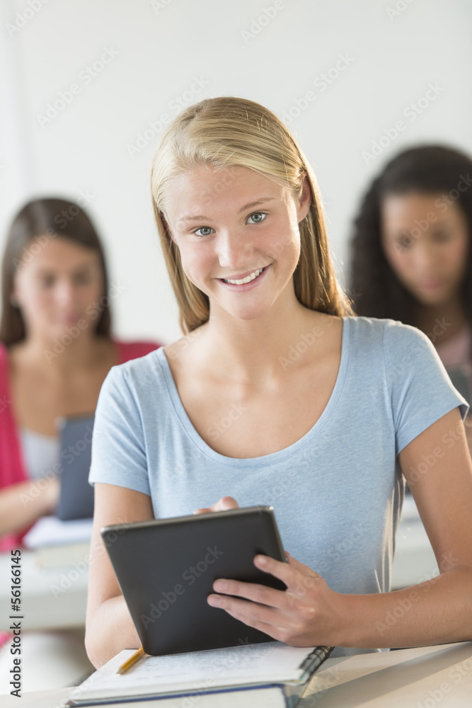 Beautiful Teenage Student Holding Digital Tablet At Desk