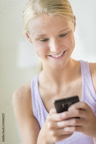 Beautiful Girl Reading Text Message On Mobile Phone