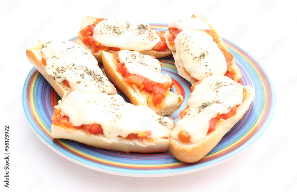 Casserole with mozzarella, tomato and basil on colored plate Casserole with mozzarella, tomato and basil on colored plate