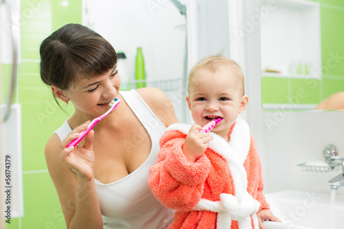 mother with baby brushing teeth